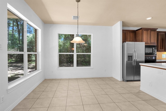 kitchen featuring hanging light fixtures, light countertops, light tile patterned floors, visible vents, and black appliances