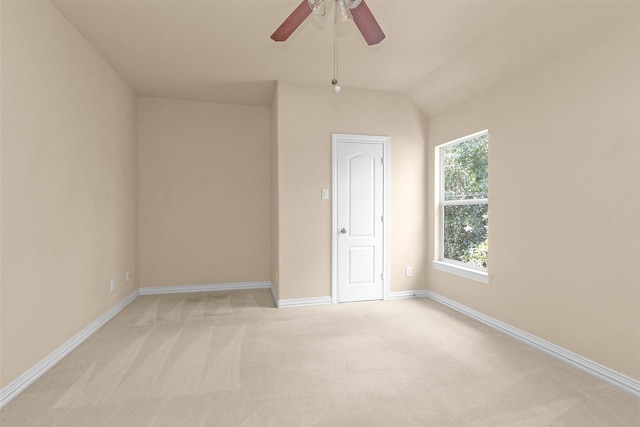 spare room featuring baseboards, light colored carpet, and ceiling fan