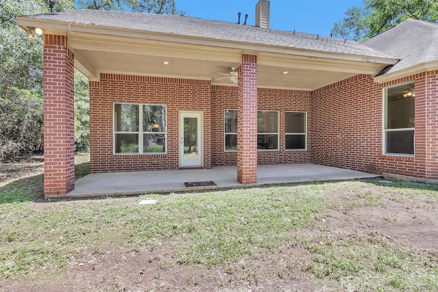back of house with a ceiling fan, a chimney, a patio area, and brick siding