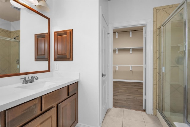 full bathroom featuring tile patterned flooring, vanity, a shower stall, a spacious closet, and visible vents