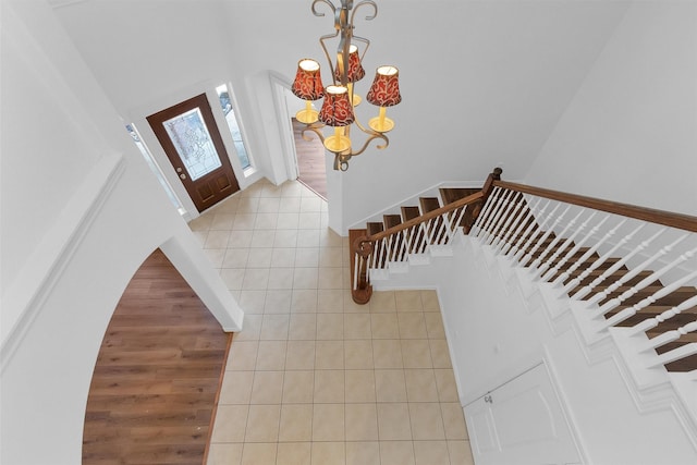 entrance foyer with stairs, light tile patterned flooring, and a chandelier