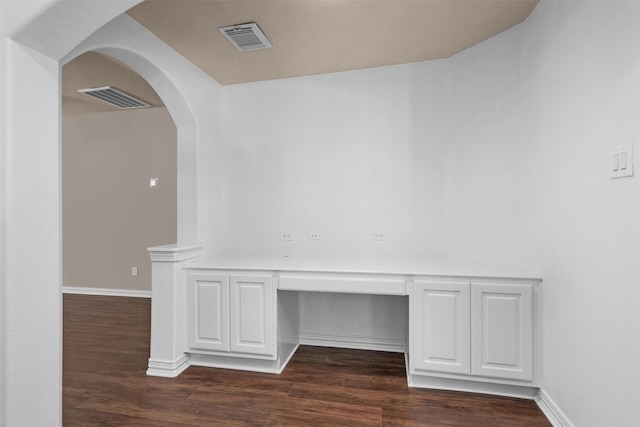interior space with arched walkways, baseboards, dark wood-style floors, and visible vents