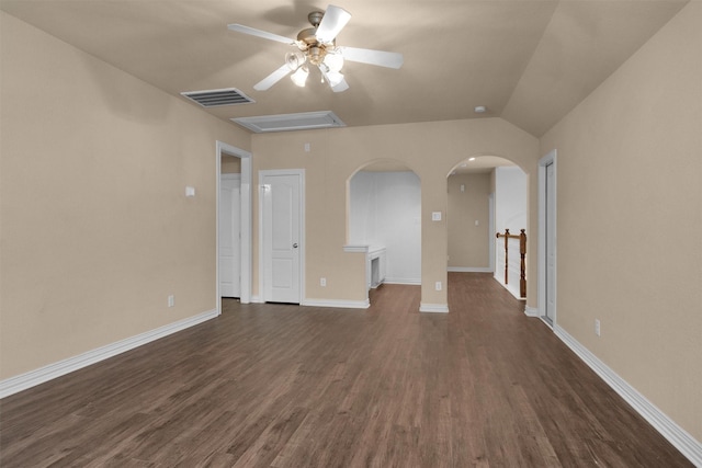 unfurnished living room with ceiling fan, arched walkways, dark wood finished floors, baseboards, and visible vents