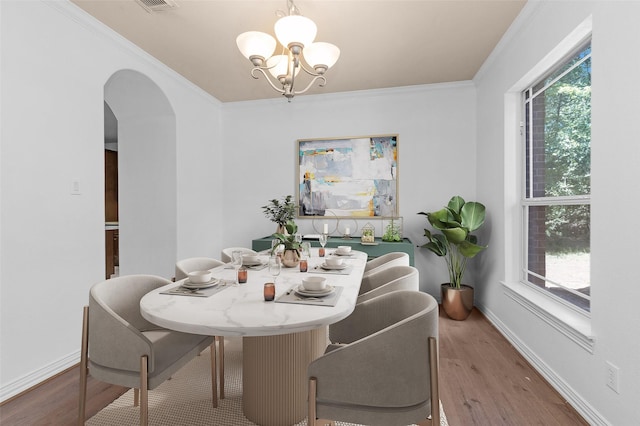 9019 Miller Rd, Magnolia, TX 77354 - dining space featuring a chandelier, arched walkways, plenty of natural light, wood finished floors, and crown molding