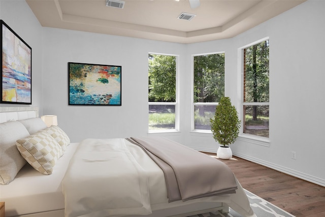 9019 Miller Rd, Magnolia, TX 77354 - bedroom featuring a tray ceiling, wood finished floors, and baseboards