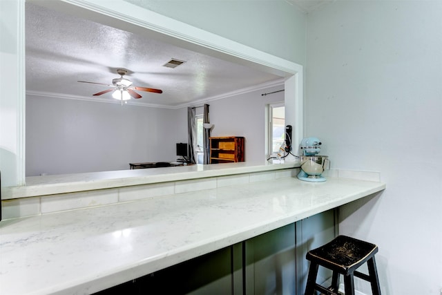 4114 Cicada Ln, Houston, TX 77039 - kitchen with visible vents, ornamental molding, a ceiling fan, and a breakfast bar