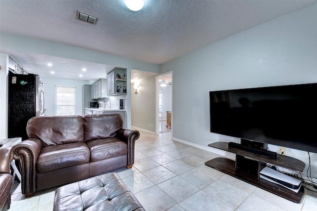 4114 Cicada Ln, Houston, TX 77039 - living room featuring light tile patterned floors, baseboards, a textured ceiling, and visible vents