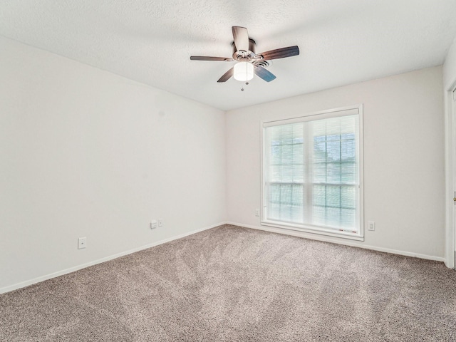 unfurnished room with baseboards, carpet flooring, ceiling fan, and a textured ceiling