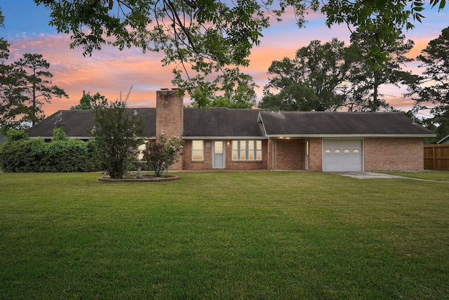 view of front of house with fence, a garage, a chimney, and a lawn