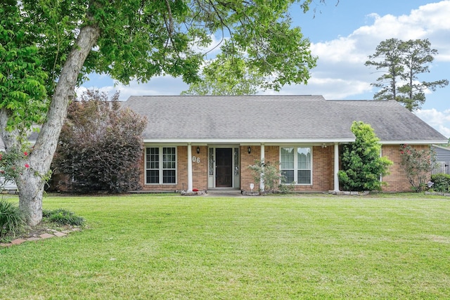 ranch-style house with a shingled roof, brick siding, and a front yard