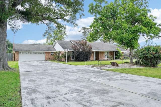 single story home featuring brick siding, fence, an attached garage, concrete driveway, and a front lawn