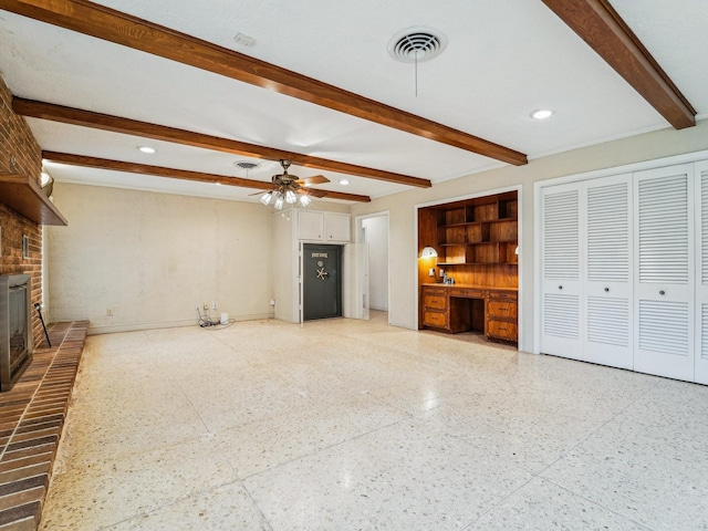 unfurnished living room featuring visible vents, light speckled floor, and beamed ceiling