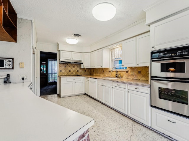 kitchen featuring a sink, stainless steel double oven, white cabinets, under cabinet range hood, and white dishwasher