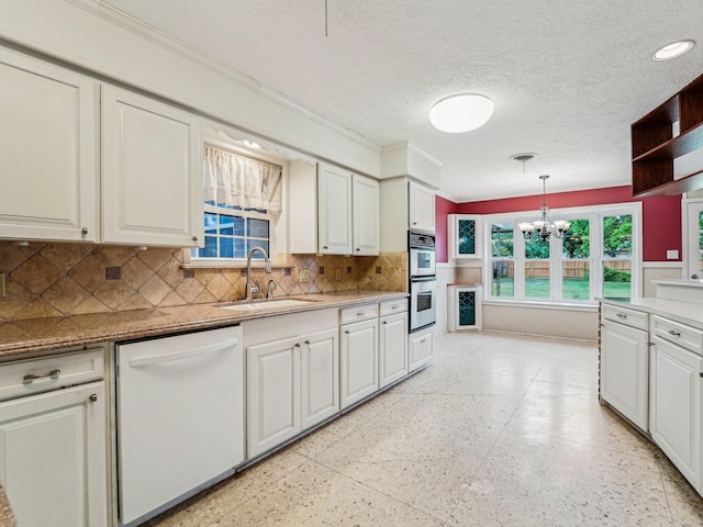kitchen with a sink, tasteful backsplash, ornamental molding, a chandelier, and white dishwasher