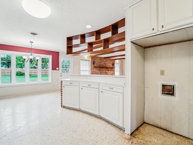 kitchen featuring light speckled floor, white cabinetry, a chandelier, open shelves, and light countertops