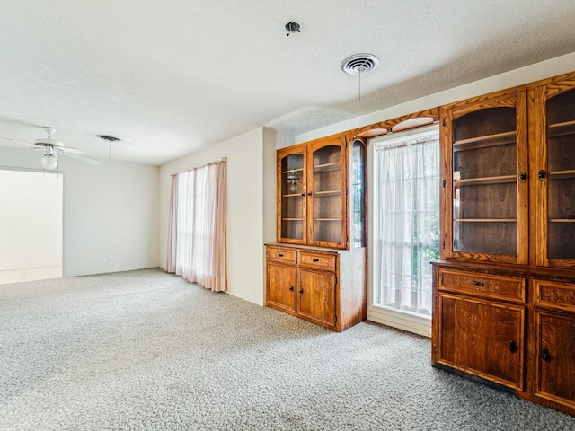 unfurnished room featuring light carpet, visible vents, and ceiling fan