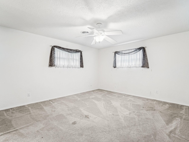 unfurnished room featuring a textured ceiling, ceiling fan, and carpet floors