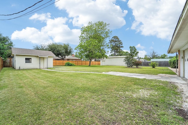 view of yard featuring an outbuilding, a patio area, and a fenced backyard