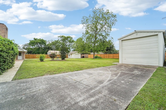 exterior space featuring an outdoor structure, a detached garage, fence, and concrete driveway