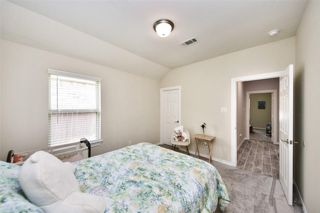 bedroom featuring light carpet, baseboards, and lofted ceiling