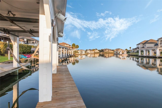 dock area featuring a water view and a residential view