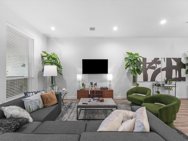 living area with baseboards, recessed lighting, wood finished floors, and visible vents