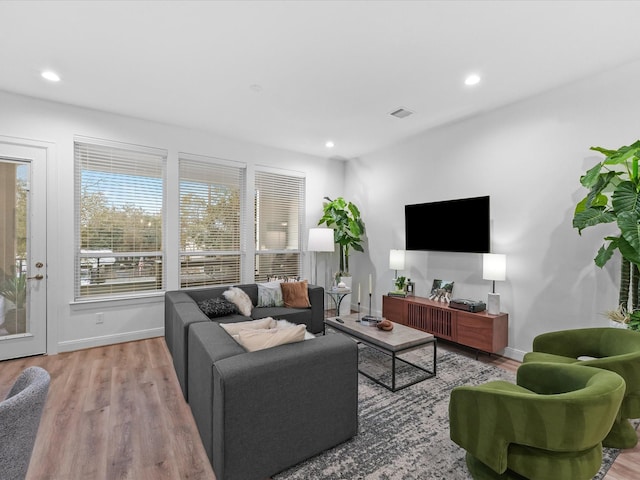 living room with recessed lighting, baseboards, and wood finished floors