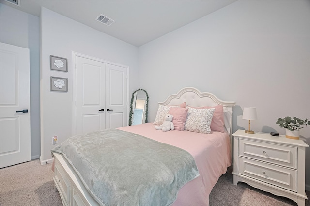 carpeted bedroom featuring baseboards, a closet, and visible vents