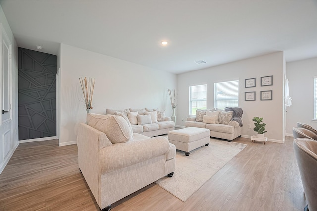 living area with visible vents, light wood-style flooring, baseboards, and recessed lighting