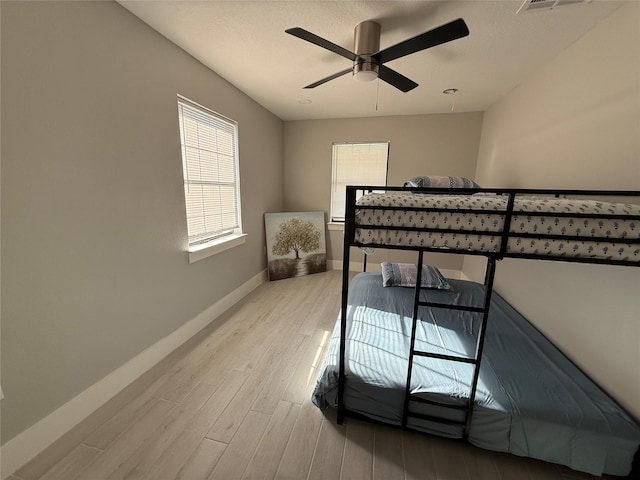 175 Heather Ln, Livingston, TX 77351 - bedroom featuring baseboards, light wood-type flooring, a ceiling fan, and multiple windows