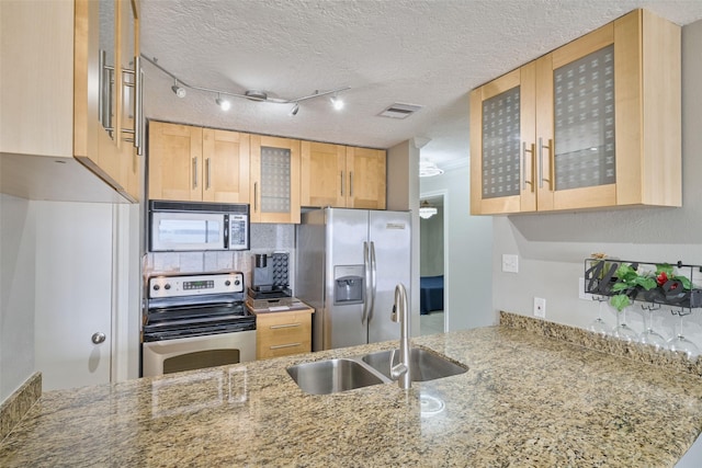 801 River Rd Unit 105D, Montgomery, TX 77356 - kitchen featuring decorative backsplash, light stone countertops, a sink, glass insert cabinets, and stainless steel appliances