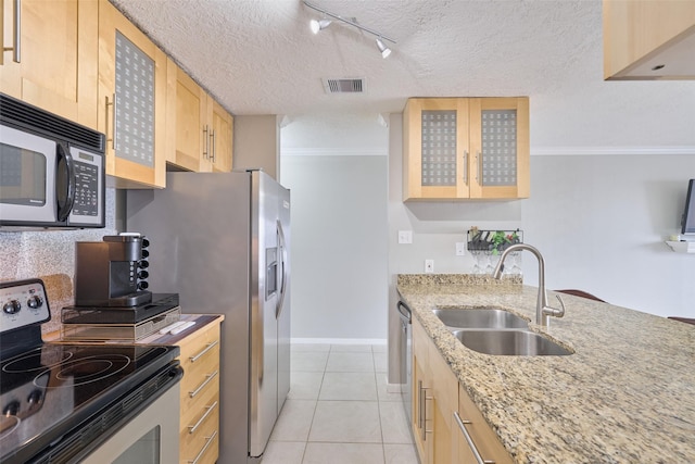 801 River Rd Unit 105D, Montgomery, TX 77356 - kitchen with light brown cabinetry, a sink, light tile patterned floors, track lighting, and stainless steel appliances