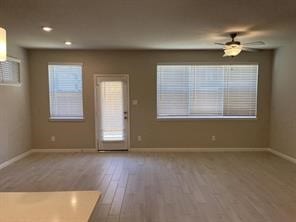 unfurnished living room featuring baseboards, recessed lighting, ceiling fan, and wood finished floors