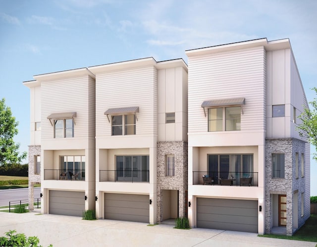 townhome / multi-family property with stucco siding, driveway, and a garage