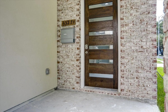 doorway to property with brick siding and stone siding