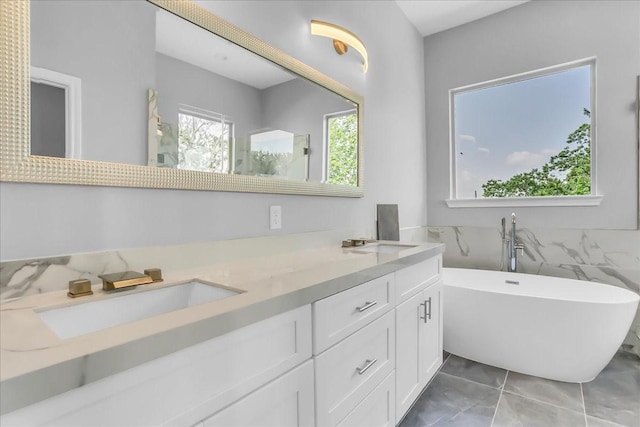 bathroom with double vanity, a sink, tile patterned floors, and a soaking tub