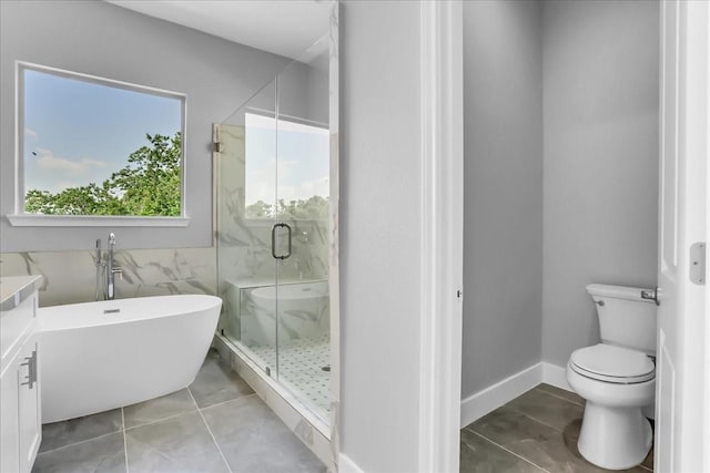 full bathroom with a freestanding tub, tile patterned flooring, a stall shower, and toilet