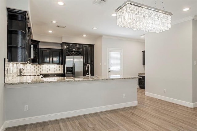 2208 Colorado St, Houston, TX 77007 - kitchen featuring stainless steel refrigerator with ice dispenser, a sink, ornamental molding, dark cabinetry, and light stone counters