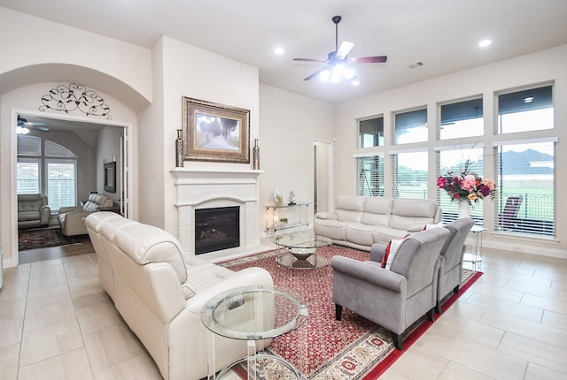 living area with recessed lighting, a glass covered fireplace, ceiling fan, and light tile patterned flooring