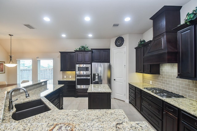 kitchen with visible vents, a center island, appliances with stainless steel finishes, and a sink