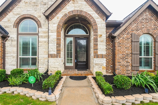 property entrance with stone siding and brick siding