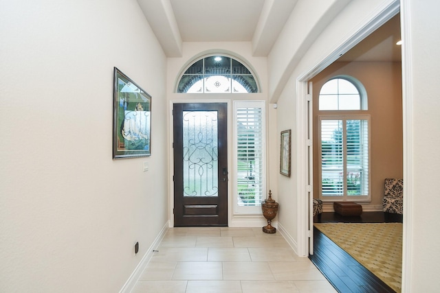 foyer entrance featuring baseboards and light tile patterned floors