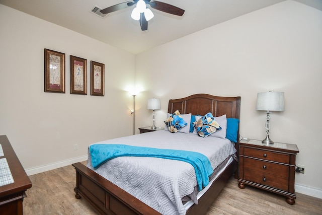 bedroom with baseboards, ceiling fan, visible vents, and wood finished floors