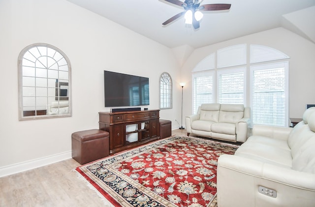 living area with lofted ceiling, baseboards, a ceiling fan, and wood finished floors