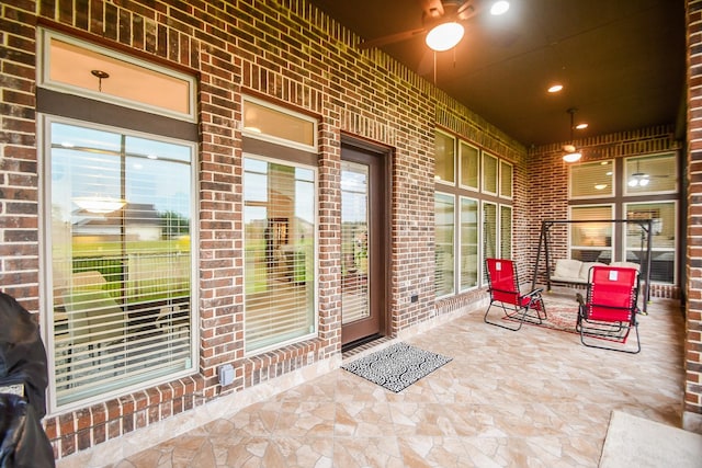 view of exterior entry with covered porch and brick siding