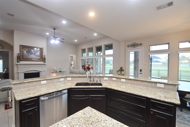 kitchen featuring a sink, stainless steel dishwasher, open floor plan, and a ceiling fan
