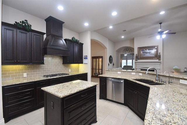 kitchen with a sink, custom range hood, arched walkways, backsplash, and appliances with stainless steel finishes