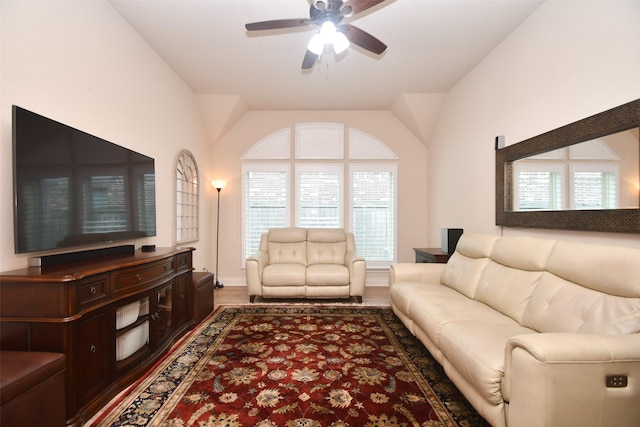 living area featuring lofted ceiling, a ceiling fan, and wood finished floors