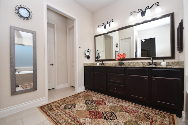 full bathroom with a sink, tiled bath, tile patterned flooring, double vanity, and baseboards