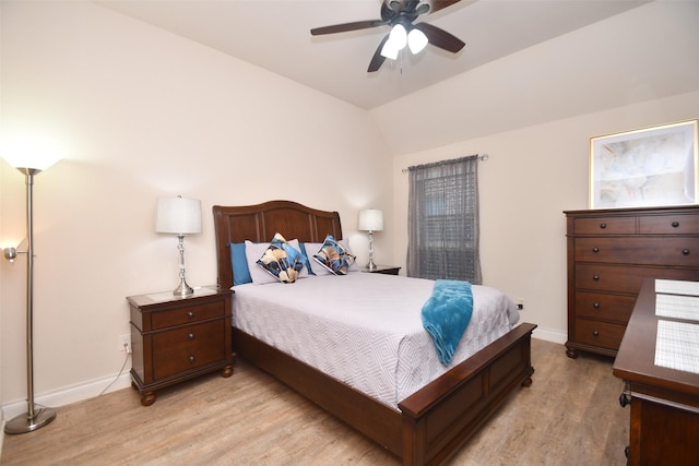 bedroom with light wood finished floors, a ceiling fan, baseboards, and lofted ceiling